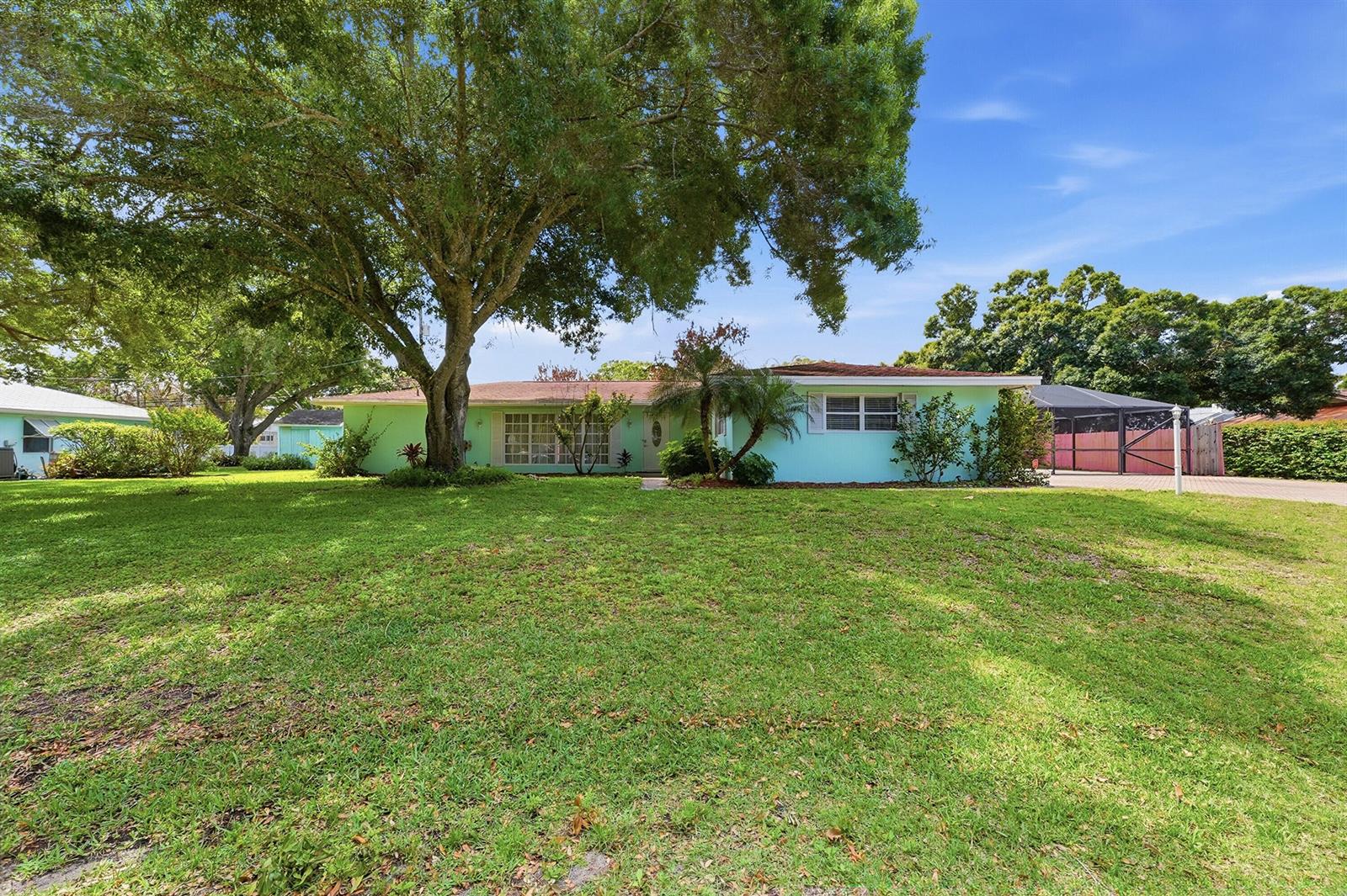 A single-story light green house with a large tree in the front yard — 2115 15th Place, Vero Beach FL 32960, VERO BEACH, FL