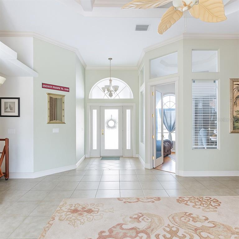A bright entryway features tile flooring, a white front door, and a ceiling fan — 8305 WELSFORD ROAD, PORT CHARLOTTE, FL