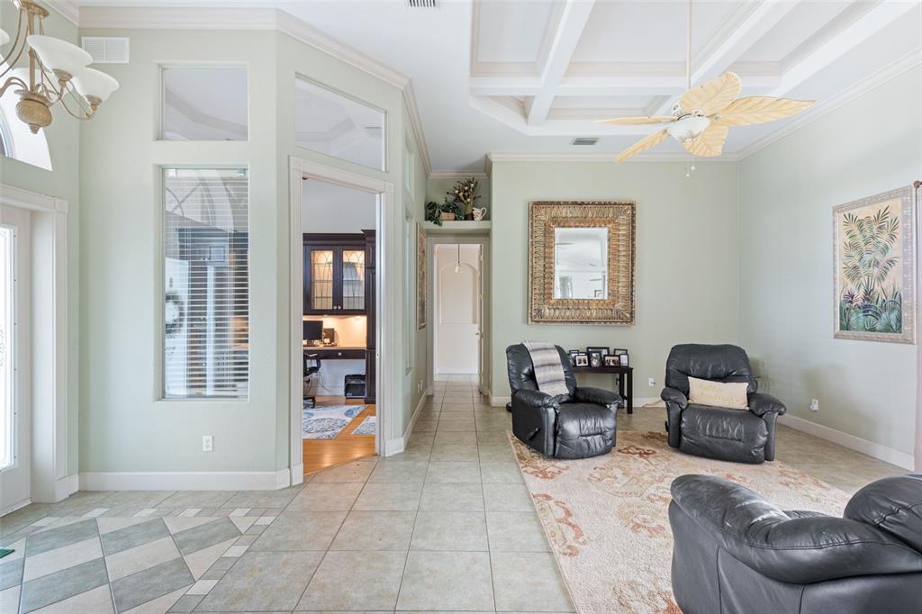 A living room with tile floors, a coffered ceiling, and three black leather recliners — 8305 WELSFORD ROAD, PORT CHARLOTTE, FL