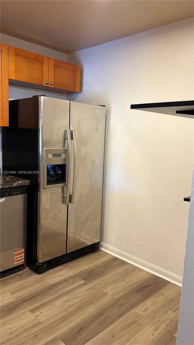 A stainless steel refrigerator stands next to a dishwasher in a kitchen with wood-look flooring — 4334 NW 9th Ave # 2F, Deerfield Beach FL 33064, DEERFIELD BEACH, FL