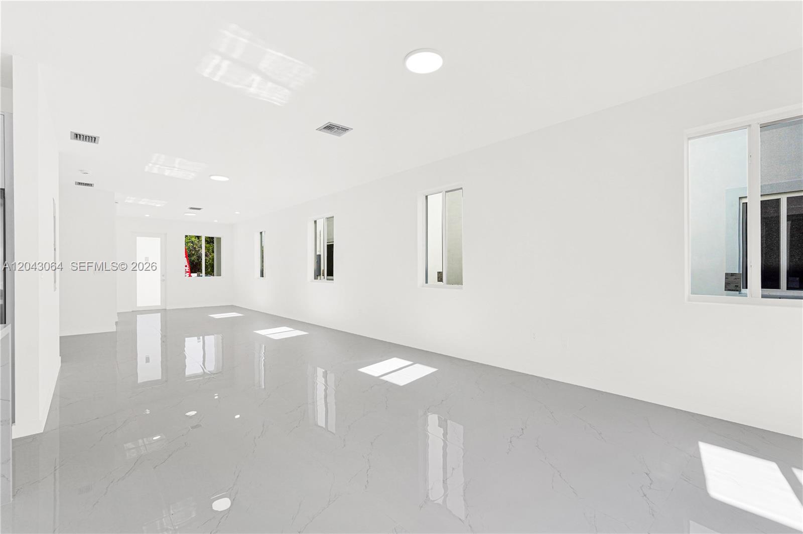 A bright, empty room features white walls, recessed lighting, and polished gray marble flooring — 22555 SW 125th Ave # 13A, Miami FL 33170, MIAMI, FL