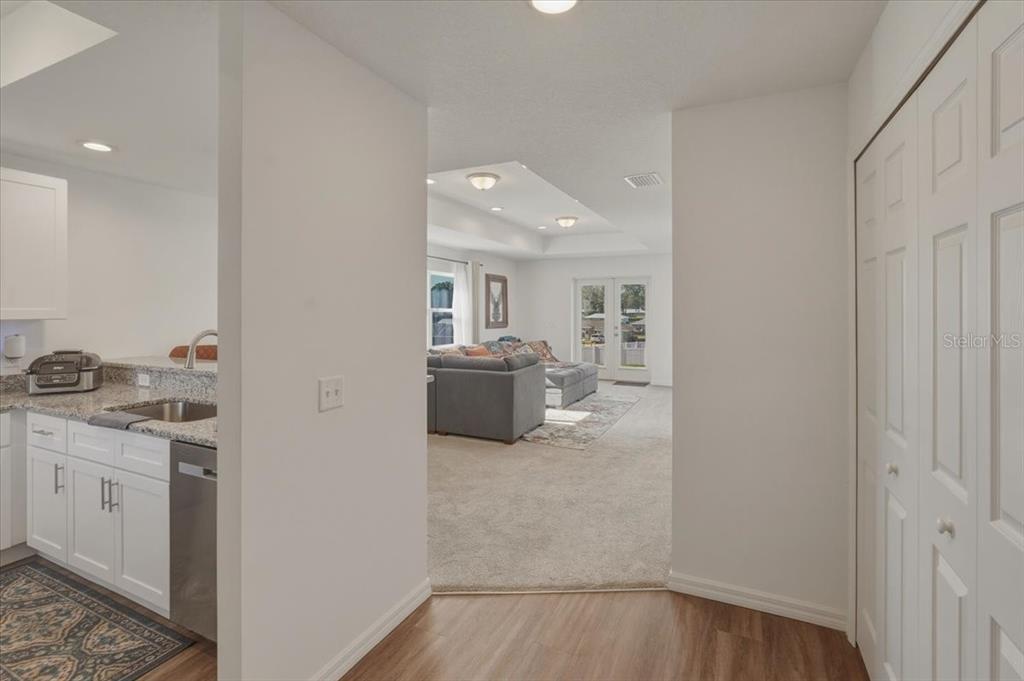 A view from a kitchen with granite countertops looking into a carpeted living room — 4447 E TAPER STREET, INVERNESS, FL