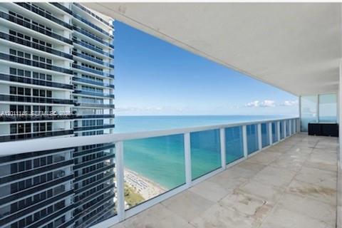 A wide balcony with stone flooring overlooks the ocean and a neighboring high-rise building — 1830 S Ocean Dr # 3308, Hallandale Beach FL 33009, HALLANDALE BEACH, FL