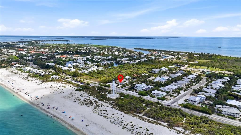 An aerial view shows a lighthouse on a sandy beach near coastal residential homes — 201 WHEELER ROAD, BOCA GRANDE, FL