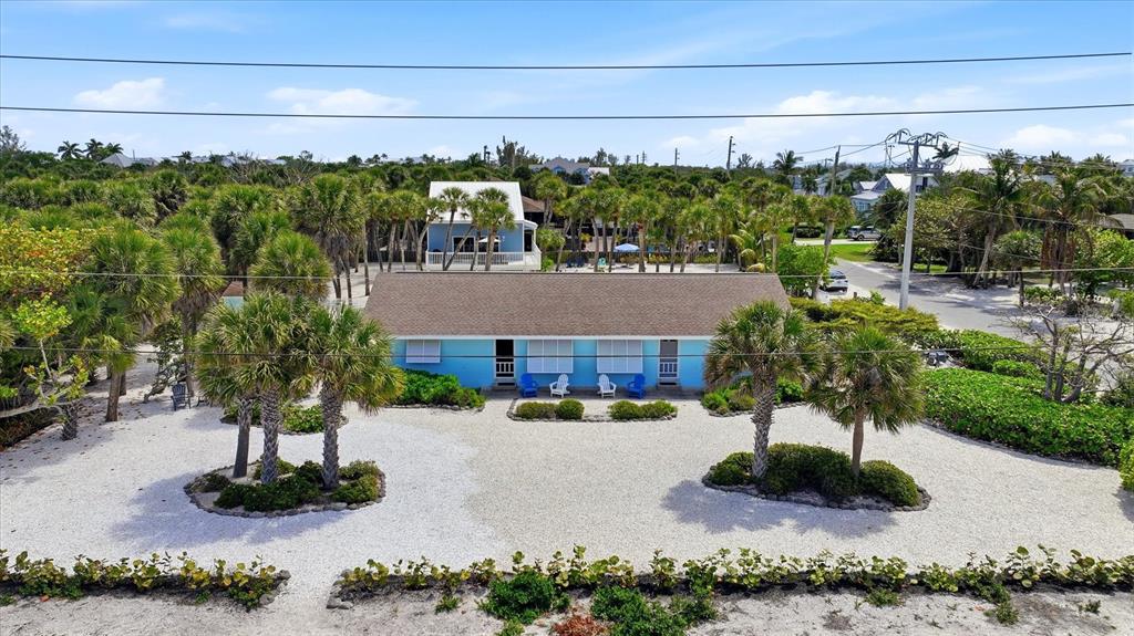 An aerial view shows a blue single-story house with a gravel yard and palm trees — 201 WHEELER ROAD, BOCA GRANDE, FL