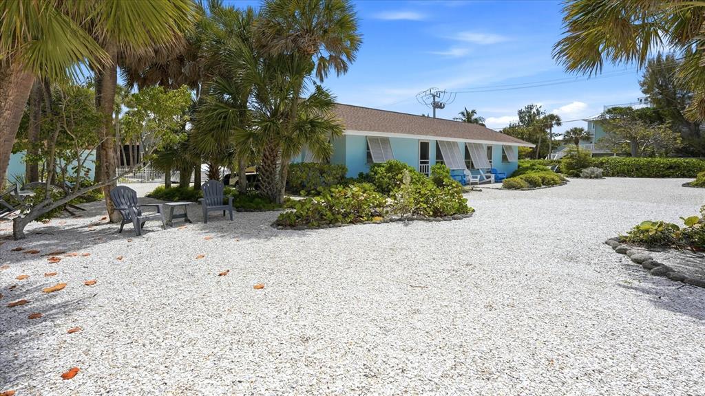 A light blue single-story house sits behind a large gravel yard with palm trees — 201 WHEELER ROAD, BOCA GRANDE, FL