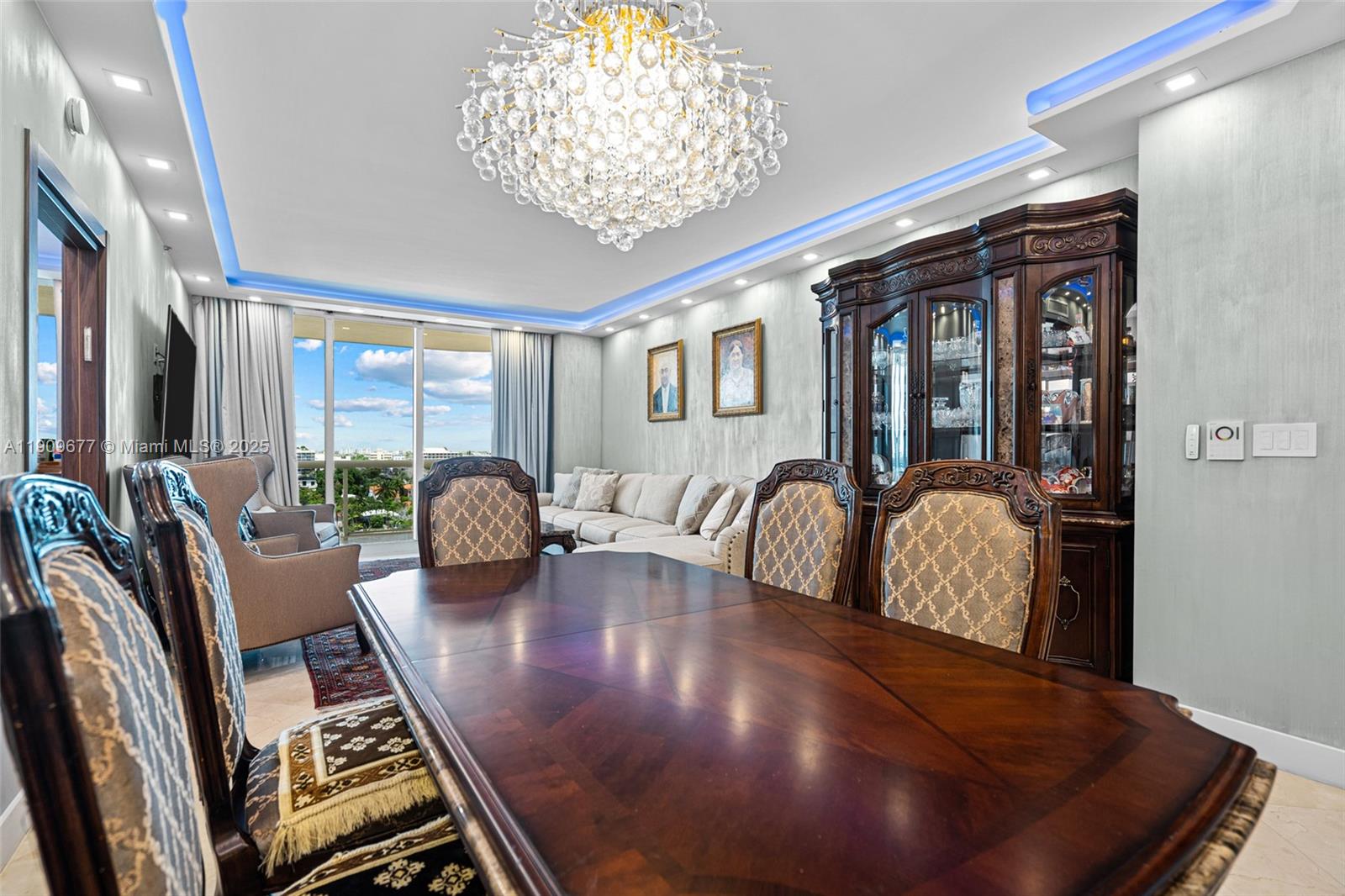 A dining room features a large wooden table, ornate chairs, a crystal chandelier, and balcony views — 9559 Collins Ave # F, Surfside FL 33154, SURFSIDE, FL