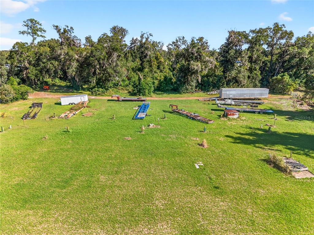 An aerial view shows a large, grassy lot containing several trailers and equipment — 10389 SE 50TH AVENUE, BELLEVIEW, FL