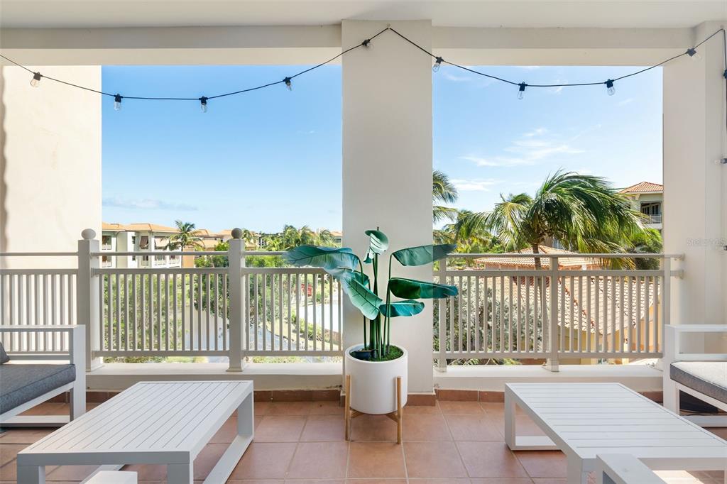A covered balcony features white railings, two white tables, a potted plant, and string lights — 75 OCEAN DRIVE UNIT 336, HUMACAO, PR