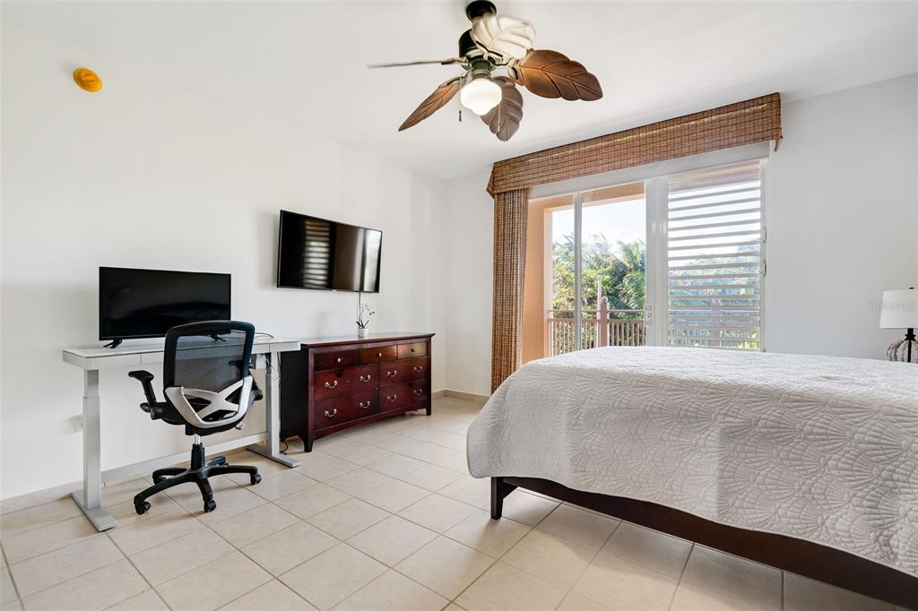 A bedroom features a desk, a dresser with a wall-mounted television, and a sliding glass door — 75 OCEAN DRIVE UNIT 336, HUMACAO, PR