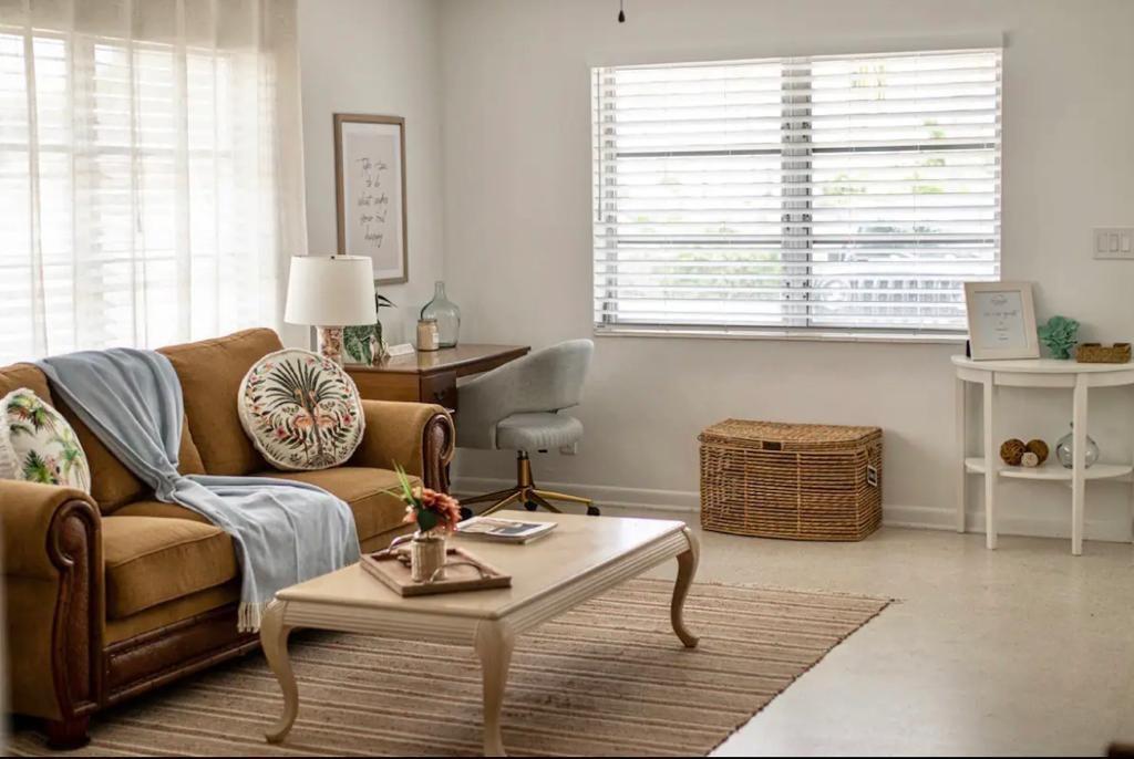 A living room features a brown sofa, coffee table, desk, and a window with blinds — 3232 NE 15th Street, Pompano Beach FL 33062, POMPANO BEACH, FL
