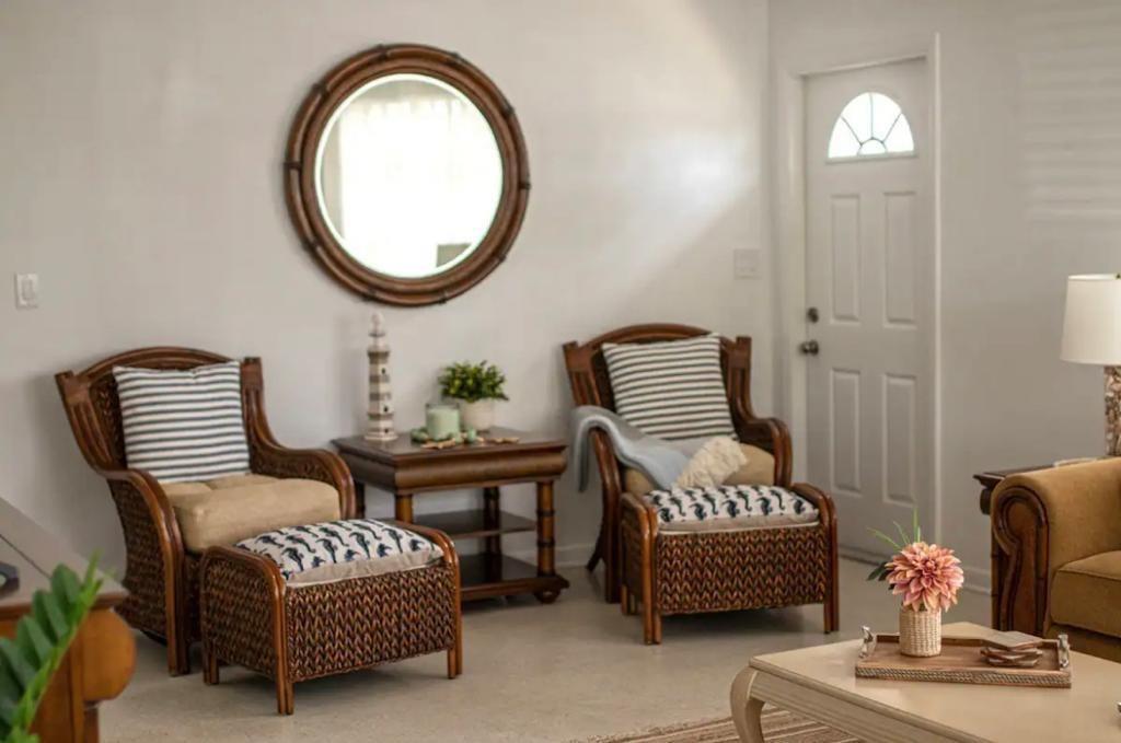 A living room features two wicker armchairs with ottomans, a side table, and a round mirror — 3232 NE 15th Street, Pompano Beach FL 33062, POMPANO BEACH, FL