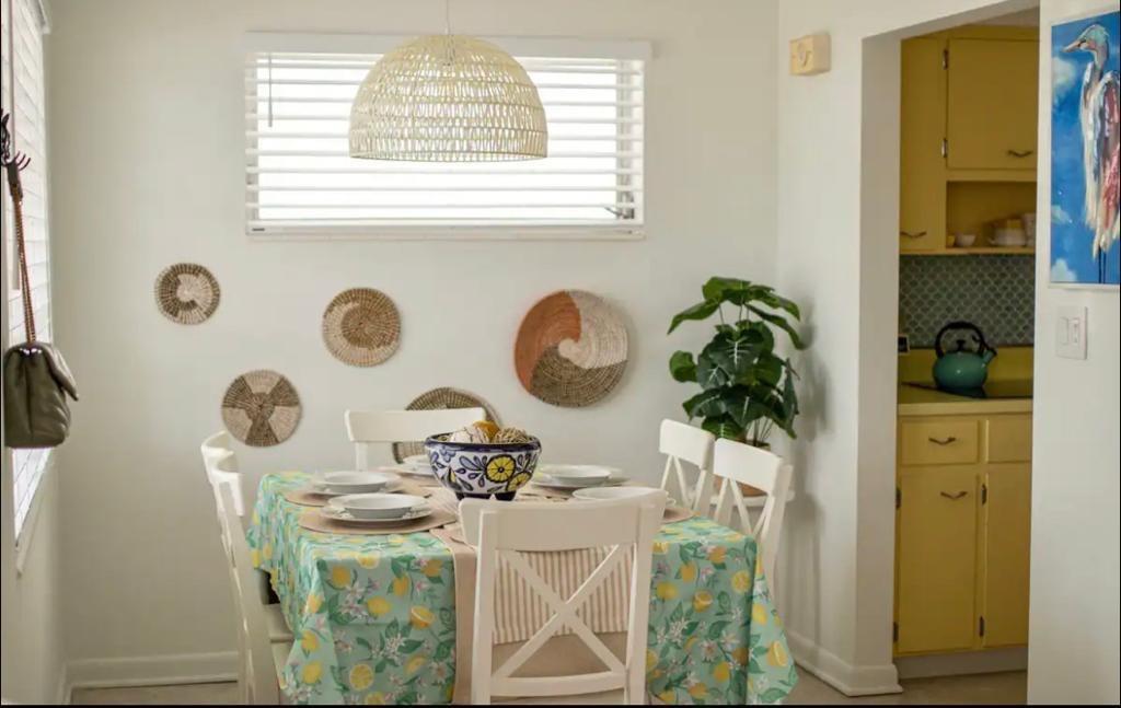 A dining area features a lemon-patterned tablecloth, woven wall baskets, and a view into a kitchen — 3232 NE 15th Street, Pompano Beach FL 33062, POMPANO BEACH, FL