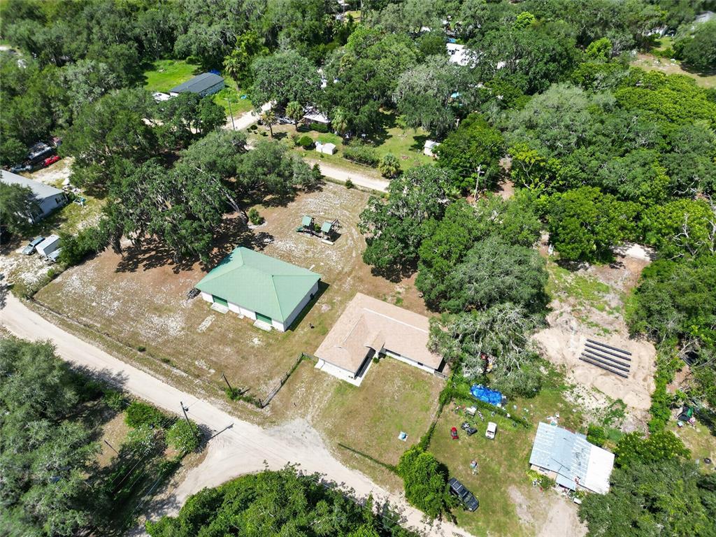 An aerial view shows a rural property with two main buildings, trees, and dirt paths — 9590 SE 190TH COURT, OCKLAWAHA, FL