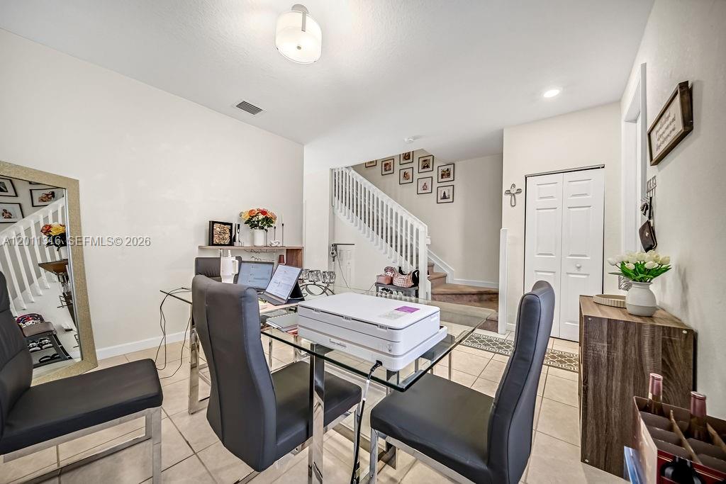 A dining room features a glass table, gray chairs, a staircase, and tile flooring — 10657 W 32nd Ln, Miami Lakes FL 33018, MIAMI LAKES, FL