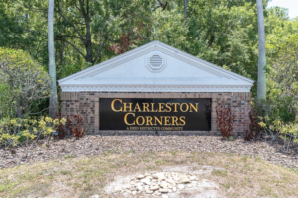 A brick monument sign for Charleston Corners stands in front of trees and landscaping — 9548 CHARLESBERG DRIVE, TAMPA, FL
