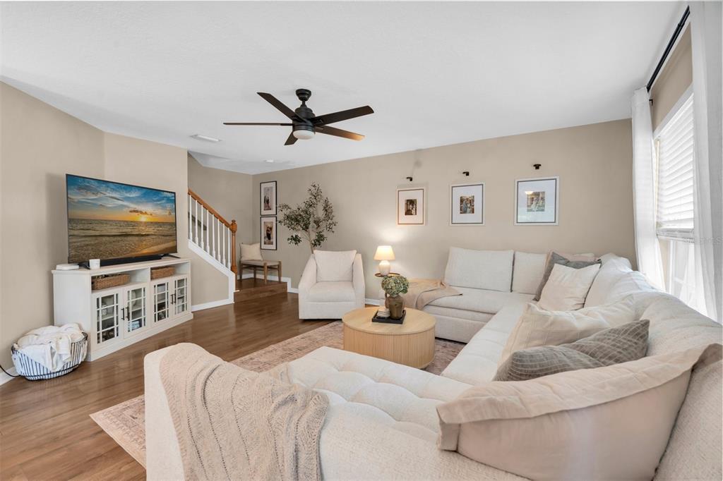A living room features a white sectional sofa, a round coffee table, and a television — 9548 CHARLESBERG DRIVE, TAMPA, FL