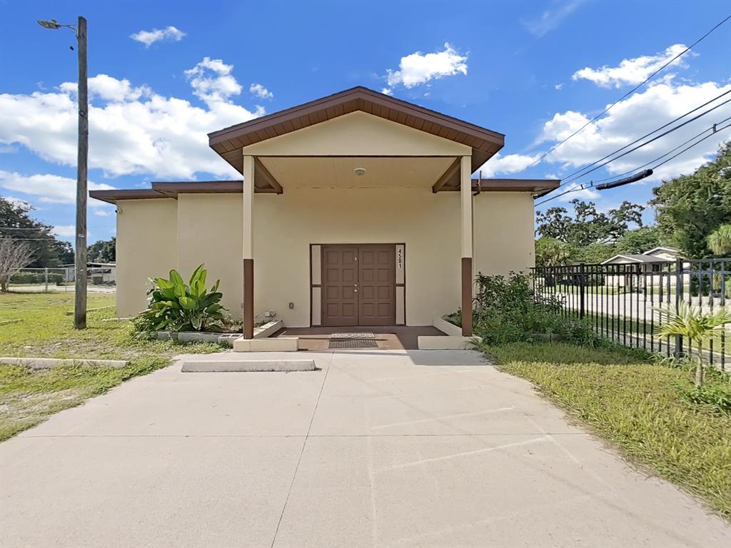 A beige building with a brown roof and double doors stands behind a concrete driveway — 4501 N 42ND STREET, TAMPA, FL