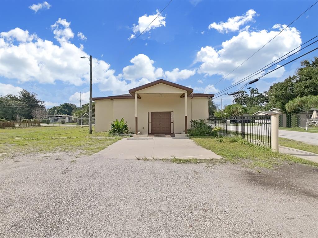 A single-story building with a covered entrance stands behind a gravel parking lot — 4501 N 42ND STREET, TAMPA, FL