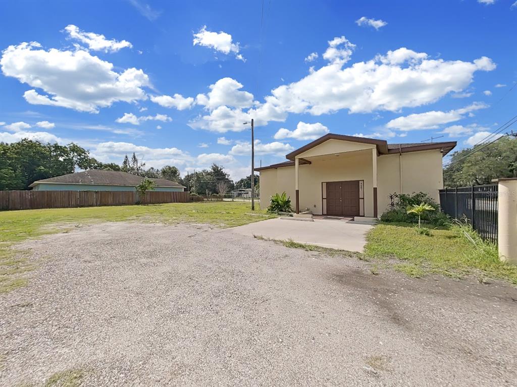 A single-story building with a covered entrance sits next to a large gravel parking lot — 4501 N 42ND STREET, TAMPA, FL