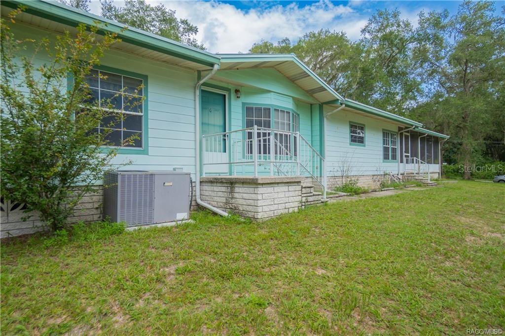 A light blue single-story house with a brick foundation, metal roof, and a small porch — 9300 CR 647A, BUSHNELL, FL