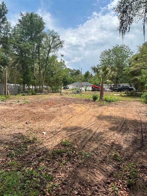 A cleared, dirt-covered residential lot with surrounding trees and a distant house — 7480 LAKEVIEW STREET, KEYSTONE HEIGHTS, FL