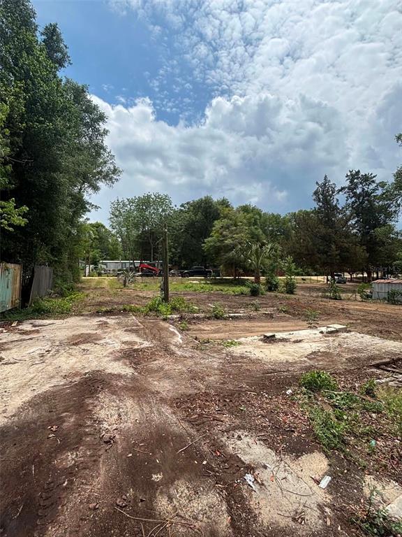 A cleared, dirt-covered lot with scattered concrete debris and surrounding trees under a cloudy sky — 7480 LAKEVIEW STREET, KEYSTONE HEIGHTS, FL