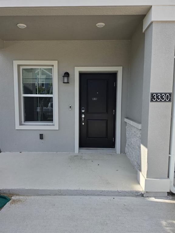 The front exterior of a house features a black door, a window, and a porch — 3330 LAURENT LOOP UNIT 3330, DAVENPORT, FL
