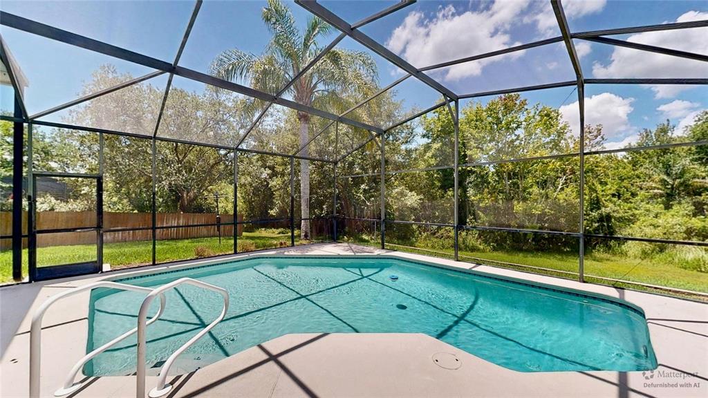 A screened-in swimming pool sits on a concrete patio surrounded by trees and grass — 2006 WINTERMERE POINTE DRIVE, WINTER GARDEN, FL