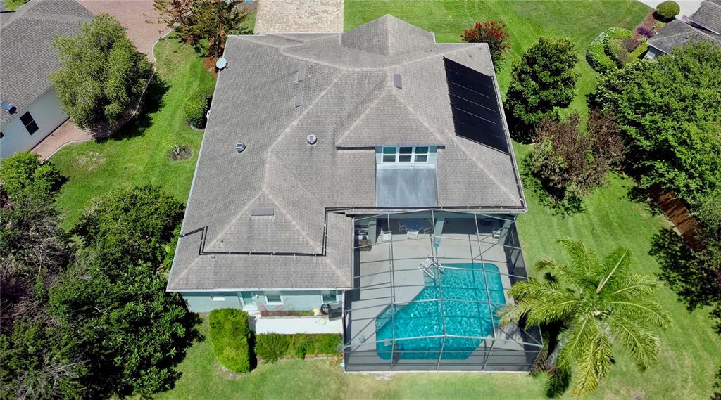 An aerial view shows a house with a shingled roof, solar panels, and a screened pool — 2006 WINTERMERE POINTE DRIVE, WINTER GARDEN, FL