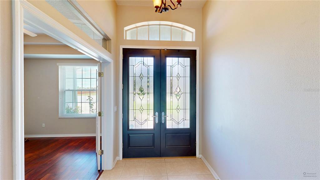 An entryway features a tiled floor, a dark double front door with glass inserts, and hardwood — 2006 WINTERMERE POINTE DRIVE, WINTER GARDEN, FL
