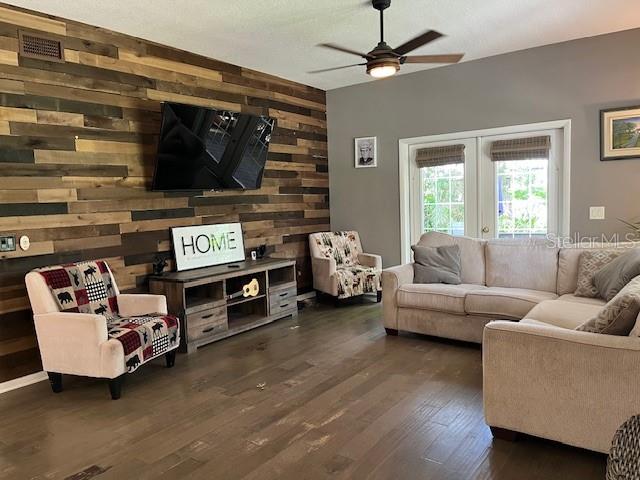 A living room features a wood-paneled accent wall, a television, and a sectional sofa — 14202 NELL DRIVE, ORLANDO, FL