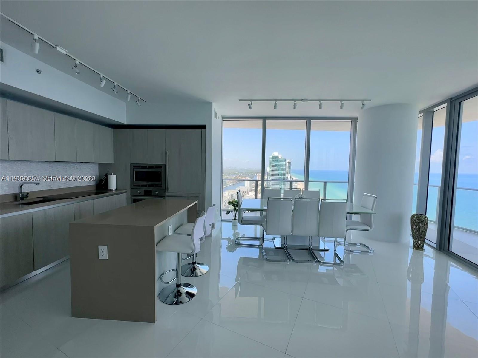 A modern kitchen and dining area with white tile floors and floor-to-ceiling ocean views — 4111 S Ocean Dr # 2902, Hollywood FL 33019, HOLLYWOOD, FL