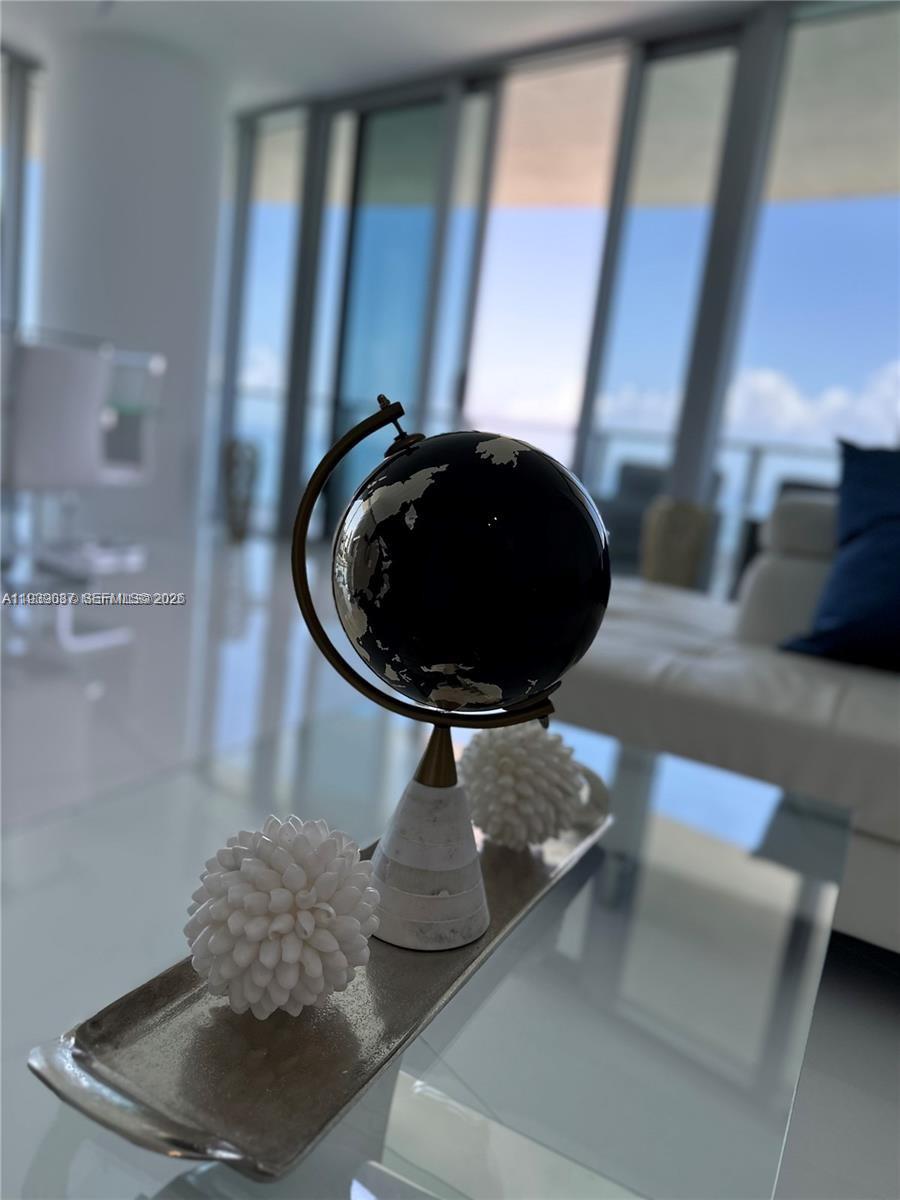 A decorative globe and two white floral-shaped ornaments sit on a tray in a room — 4111 S Ocean Dr # 2902, Hollywood FL 33019, HOLLYWOOD, FL