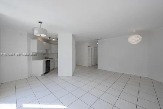 An open-concept living and dining area features white tile flooring, white walls, and a kitchen — 1688 West Ave # 08, Miami Beach FL 33139, MIAMI BEACH, FL