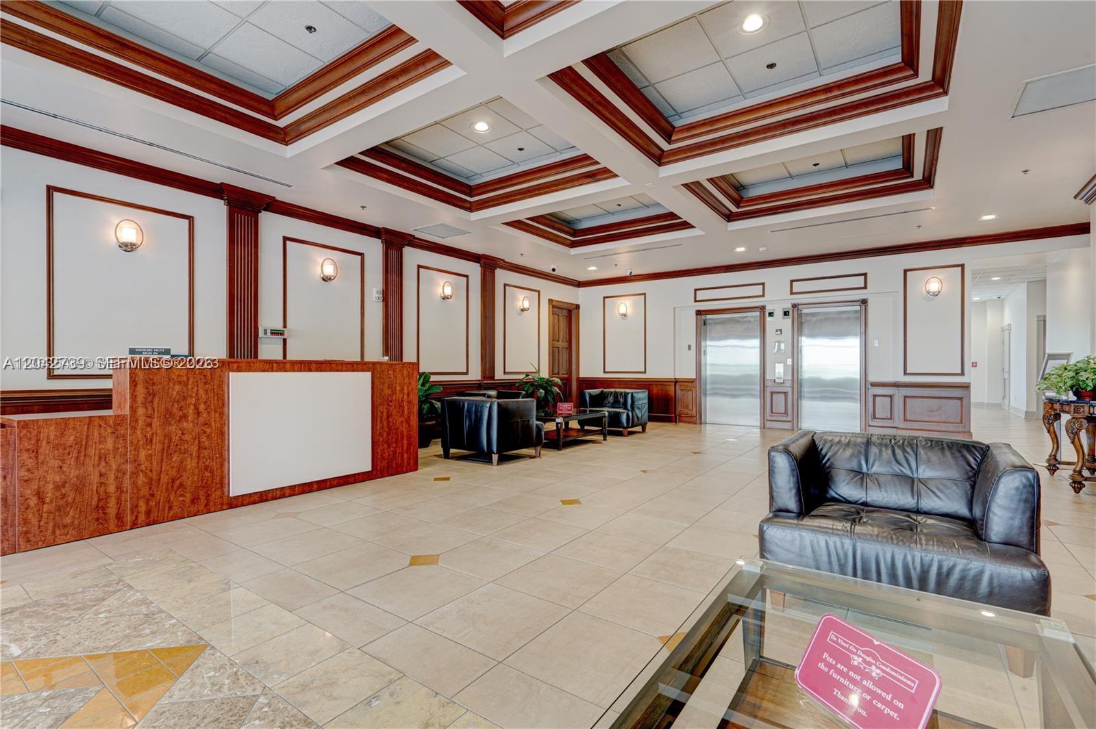 A lobby features a reception desk, leather seating, elevator doors, and a coffered ceiling — 2665 SW 37th Ave # 101, Miami FL 33133, MIAMI, FL