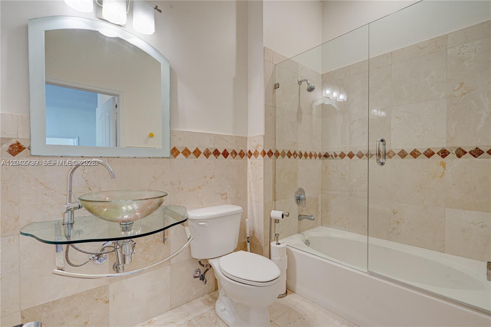 A bathroom features a glass vessel sink, a toilet, and a shower-tub combination with tile — 2665 SW 37th Ave # 101, Miami FL 33133, MIAMI, FL