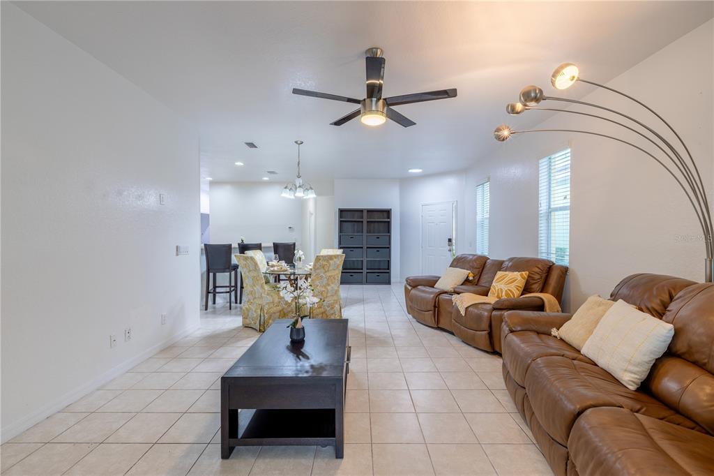 A living and dining area features tile floors, brown leather sofas, and a ceiling fan — 11447 CAPTIVA KAY DRIVE, RIVERVIEW, FL