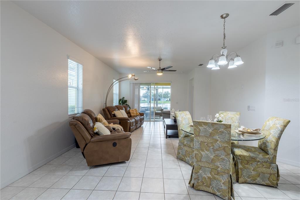 A living and dining area features tile flooring, brown leather furniture, and a glass-topped table — 11447 CAPTIVA KAY DRIVE, RIVERVIEW, FL