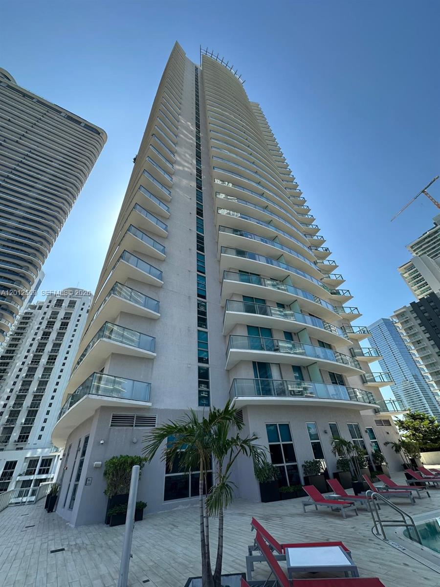 A low-angle exterior view of a tall residential high-rise building with balconies and a pool — 1100 S Miami Ave # 2608, Miami FL 33130, MIAMI, FL