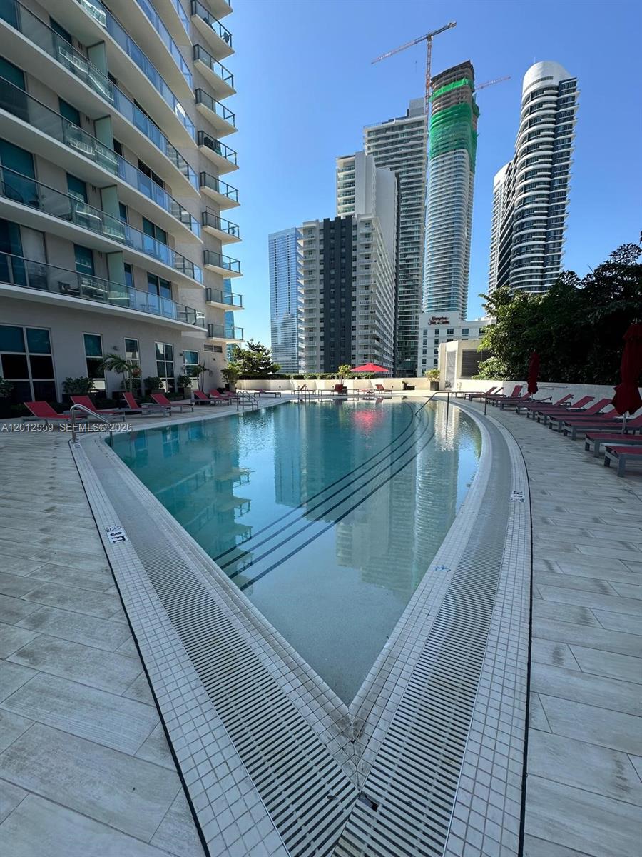 An outdoor swimming pool surrounded by lounge chairs and high-rise apartment buildings — 1100 S Miami Ave # 2608, Miami FL 33130, MIAMI, FL