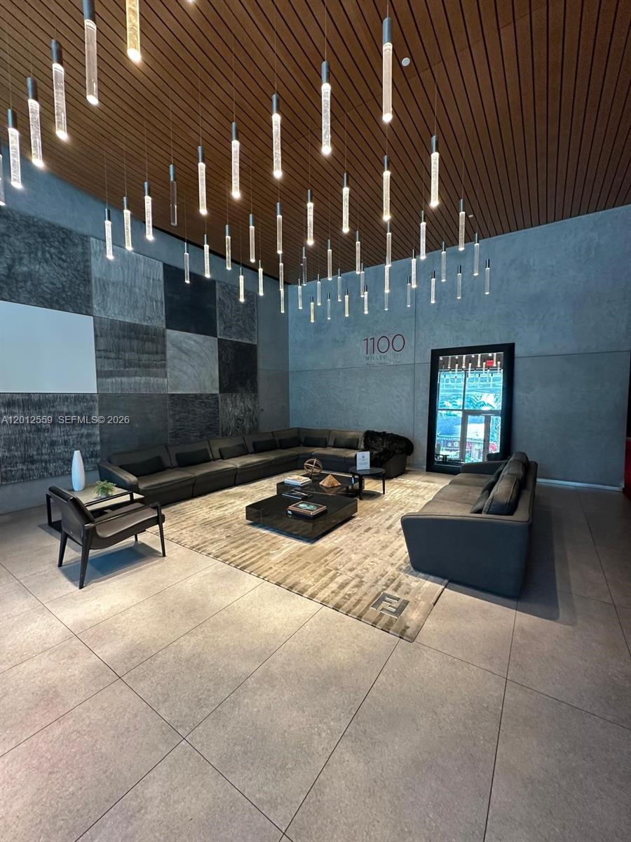 A modern lobby features a large sectional sofa, a central coffee table, and pendant lighting — 1100 S Miami Ave # 2608, Miami FL 33130, MIAMI, FL