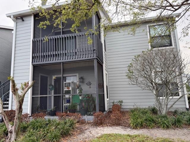 A two-story gray house features a screened-in porch and balcony with dark railings — 3700 IDLEBROOK CIRCLE UNIT 112, CASSELBERRY, FL