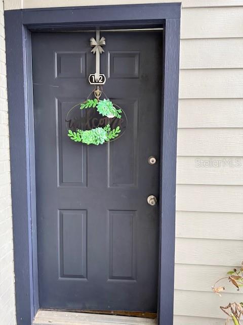 A dark blue front door features a succulent wreath and a unit number sign — 3700 IDLEBROOK CIRCLE UNIT 112, CASSELBERRY, FL