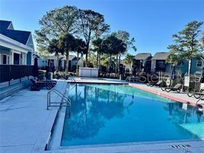 A rectangular swimming pool is surrounded by a concrete deck and residential buildings — 3700 IDLEBROOK CIRCLE UNIT 112, CASSELBERRY, FL
