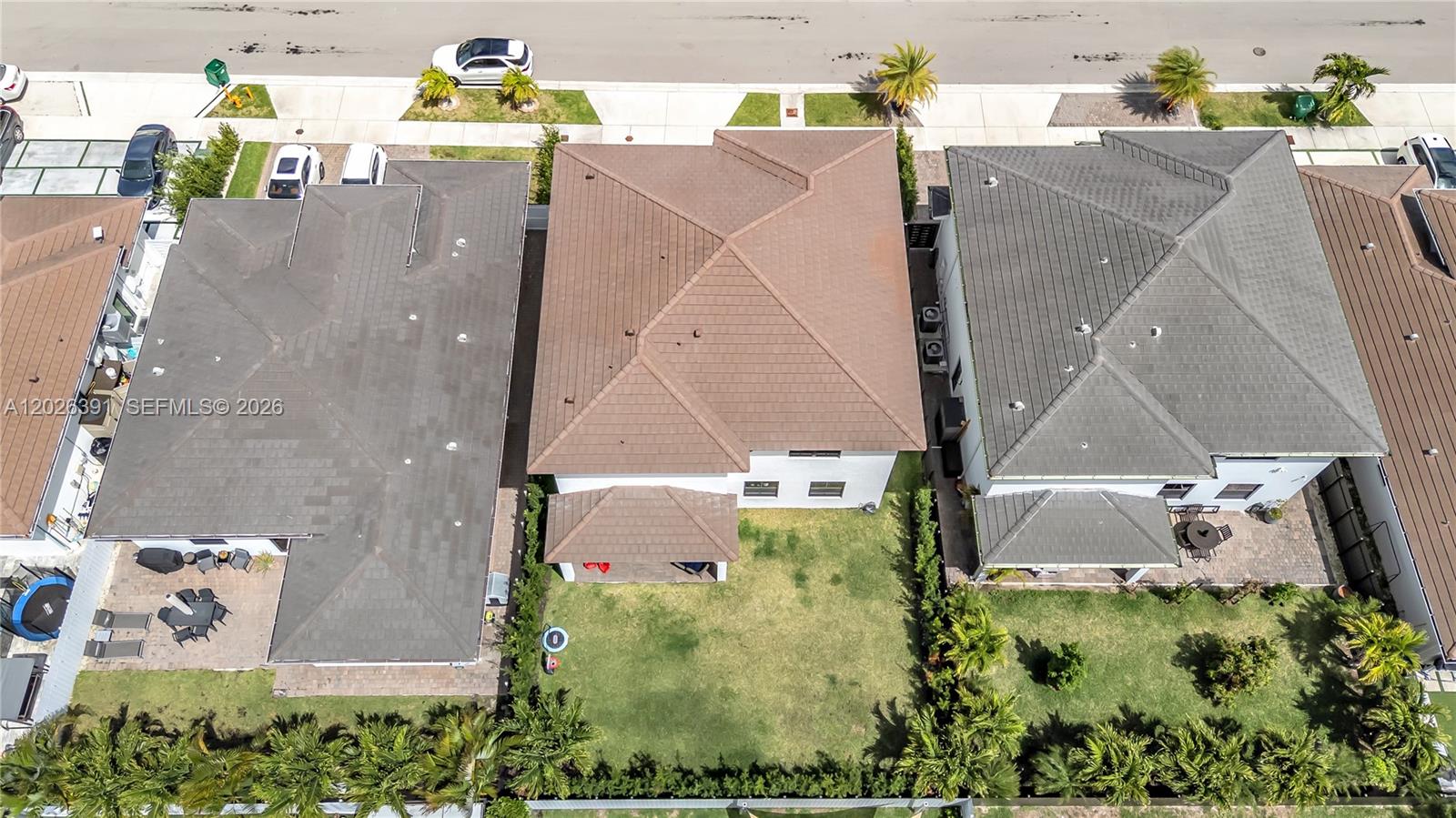 An aerial view shows three suburban houses with tiled roofs and backyards — 14606 SW 22nd Ter, Miami FL 33175, MIAMI, FL