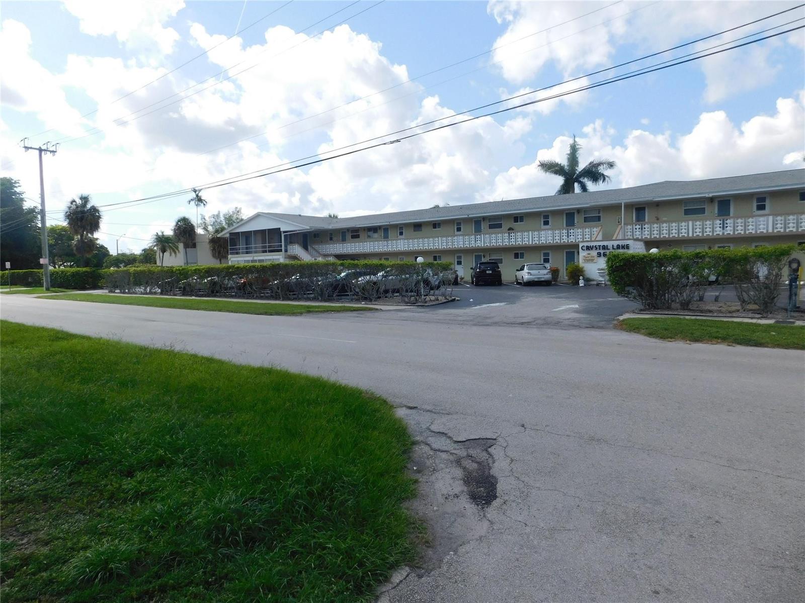 A two-story apartment building with a parking lot and landscaping viewed from the street — 960 Crystal Lake Drive # 201, Deerfield Beach FL 33064, DEERFIELD BEACH, FL
