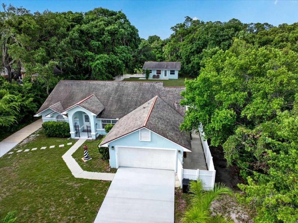 An aerial view shows a light blue house with a garage and a detached structure — 4220 N OCEAN SHORE BOULEVARD, PALM COAST, FL