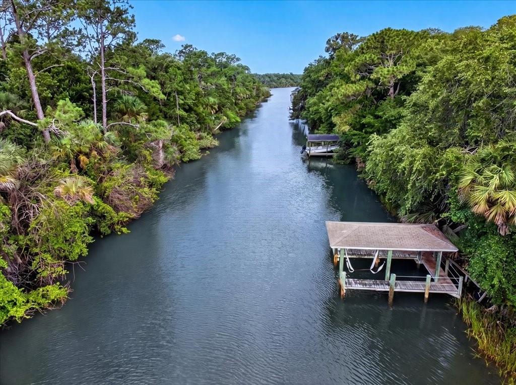 An aerial view of a narrow canal lined with dense trees and two boat docks — 4220 N OCEAN SHORE BOULEVARD, PALM COAST, FL