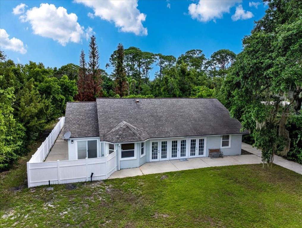 An aerial view of the rear of a single-story house with a white vinyl fence — 4220 N OCEAN SHORE BOULEVARD, PALM COAST, FL